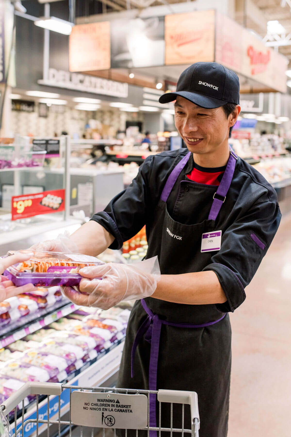A man in a store holding sushi